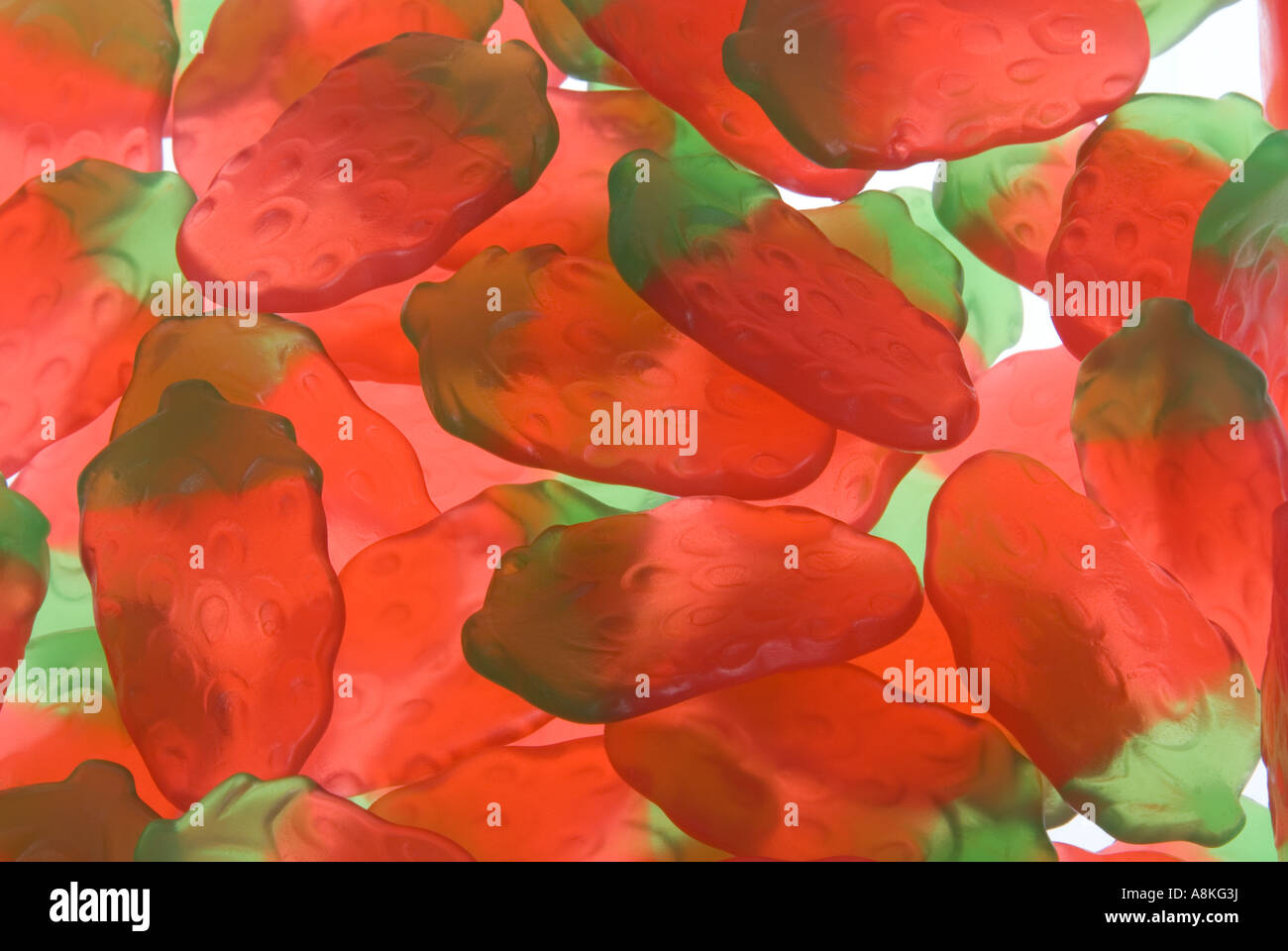 Chiudere orizzontale delle partite di fragole a forma di caramelle gommose su uno sfondo bianco. Foto Stock