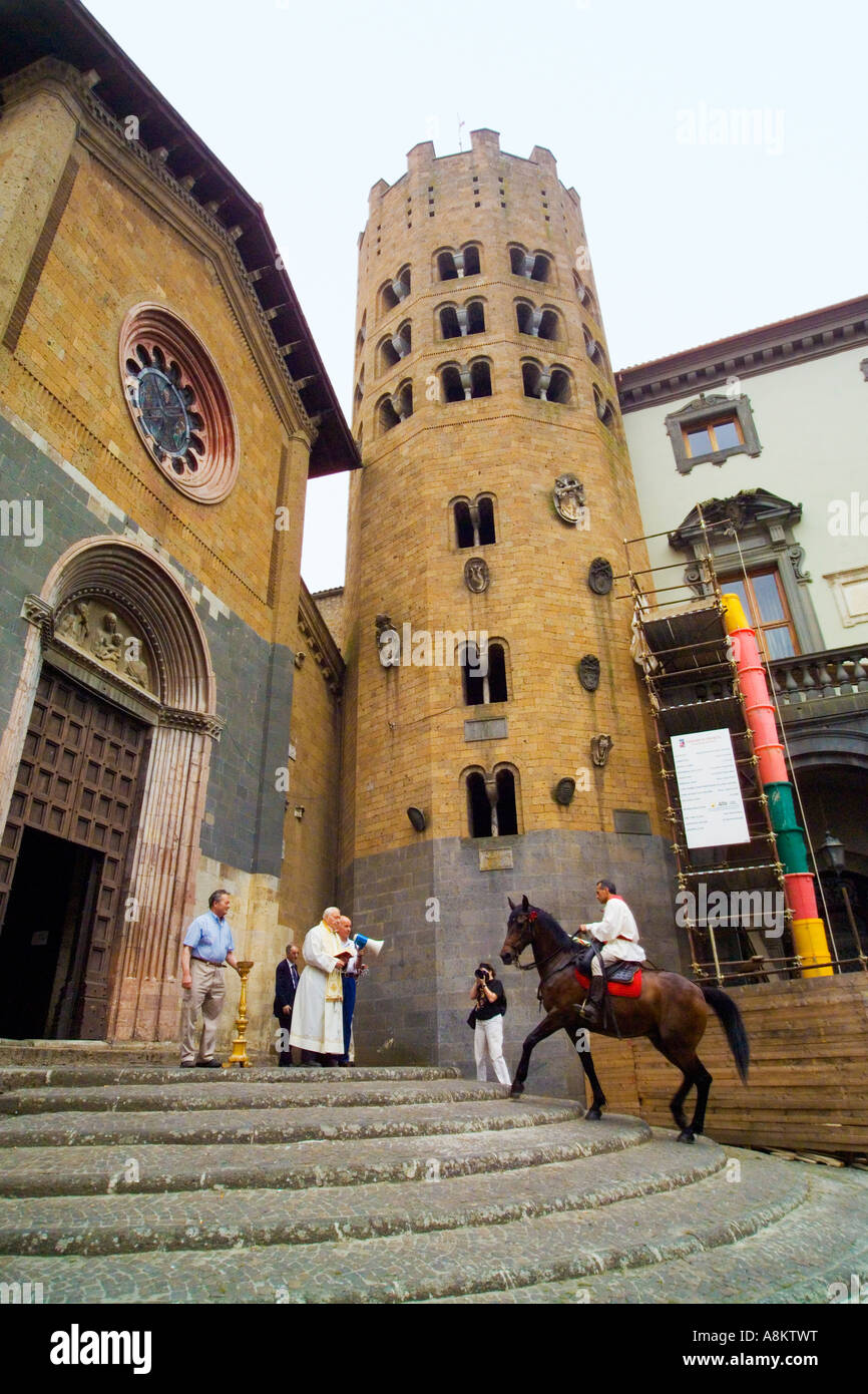Rider monta passi per soddisfare sacerdote per la benedizione prima dell'annuale Palio dell'oc cavallo di razza in Orvieto Umbria Italia. JMH2907 Foto Stock