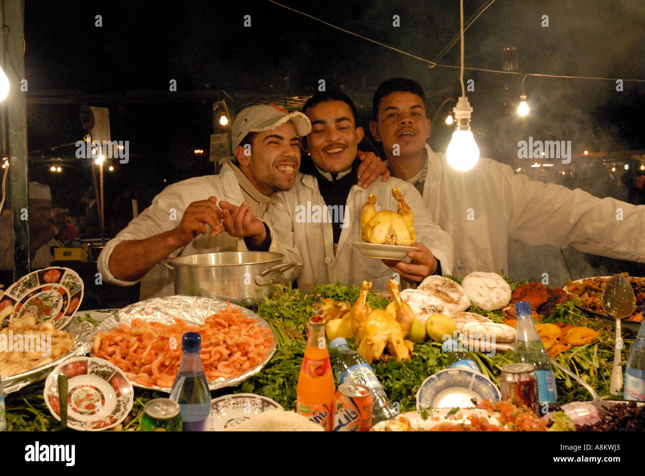 Gli uomini marocchini venditori di cibo sul cibo in stallo durante la notte Piazza Djemaa El Fna a Marrakech Marrakech marocco Foto Stock