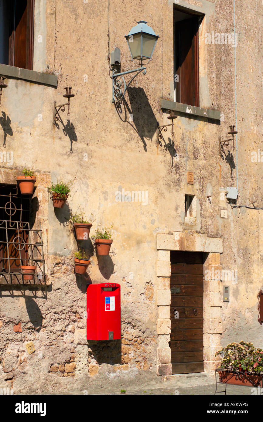Parete del vecchio edificio in pietra in Orvieto Umbria Italia con red post box e lampada. JMH2923 Foto Stock