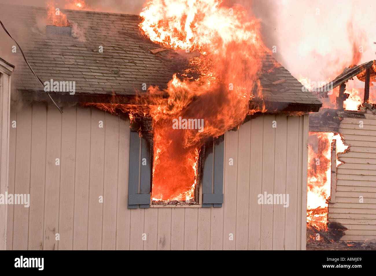 Le fiamme con la ripresa di una casa sul fuoco Foto Stock