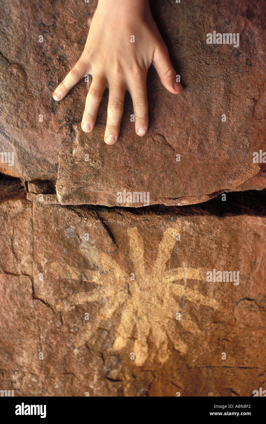 Bambino la mano accanto all'antica arte rupestre degli Aborigeni di Arnhem Land Territorio del Nord Australia Foto Stock