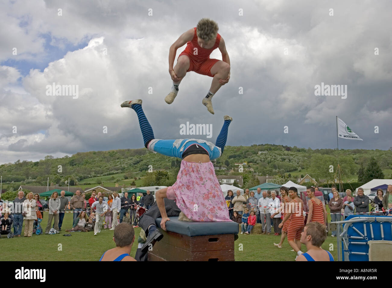 Canguri ginnastica per la squadra di visualizzazione in Edwardian costumi somersaulting sulla confezione lunga Mayday Costwolds REGNO UNITO Foto Stock