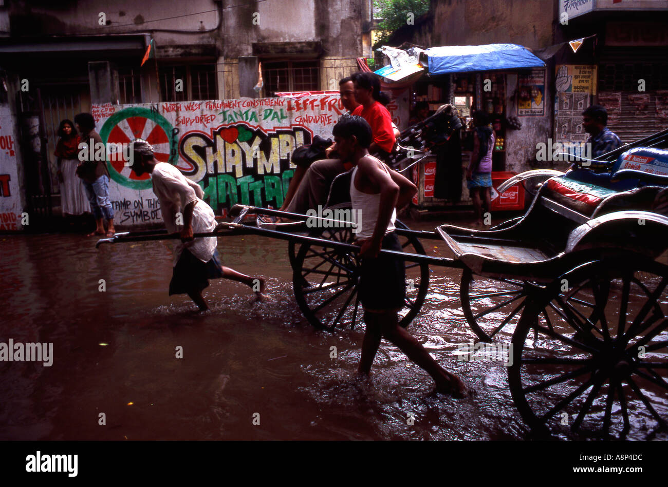 In rickshaw drivers di Calcutta lottando attraverso il loods a causa della stagione delle piogge monsoniche Foto Stock