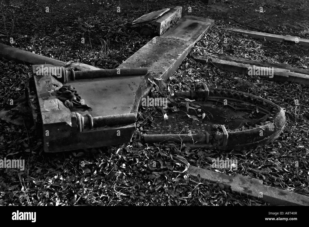 Storica pietra tombale soggetto ad atti vandalici caduti rotto in bianco e nero nel cimitero di Rookwood Sydney Australia Oceania Foto Stock