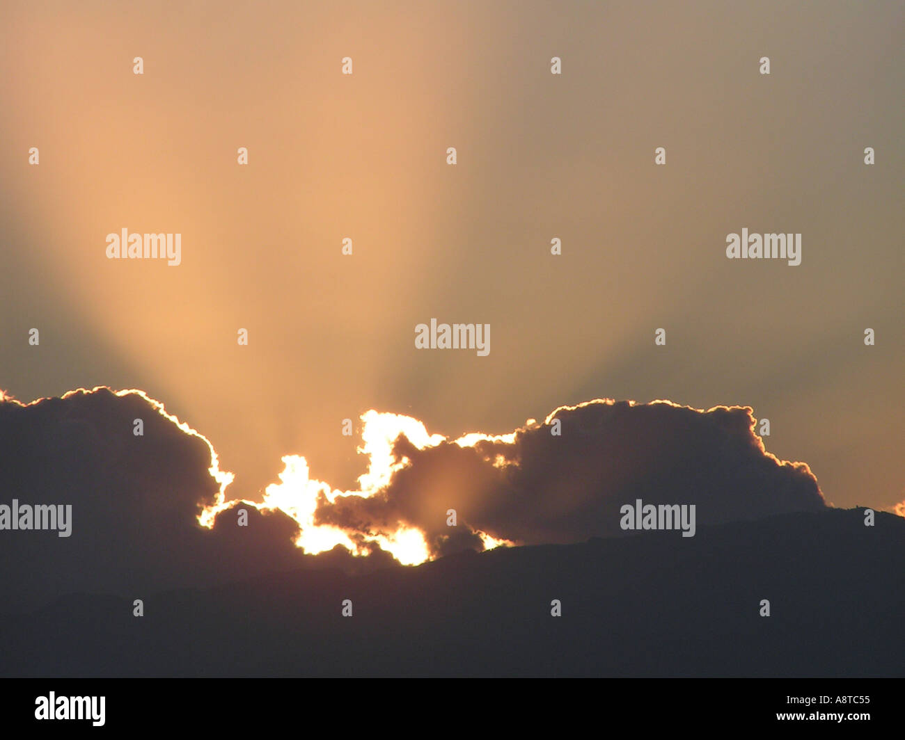 Raggi di sole da dietro il cloud sky per lo sfondo della pagina Foto Stock