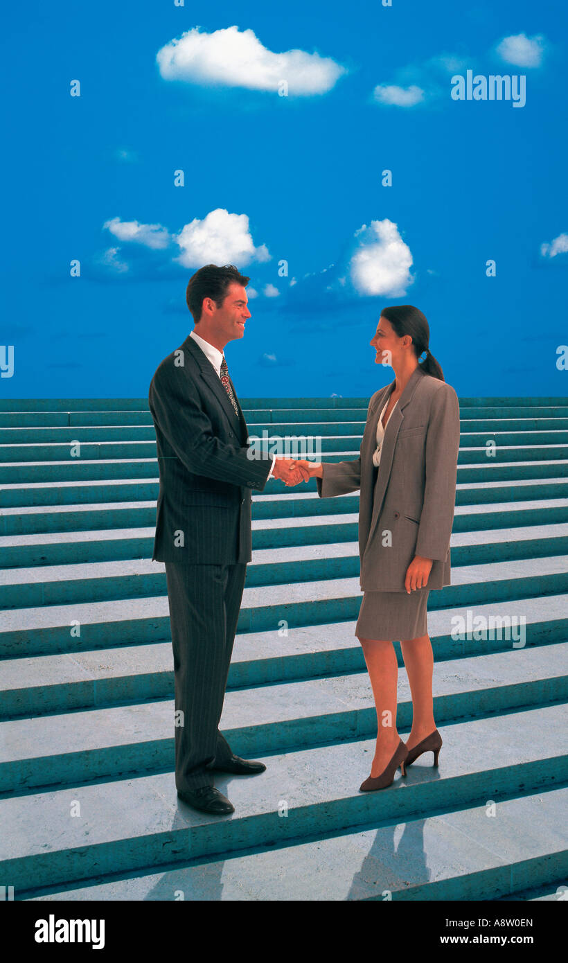 Montage concetto di uomo e donna si stringono la mano mentre in piedi sui gradini contro il cielo blu. Foto Stock