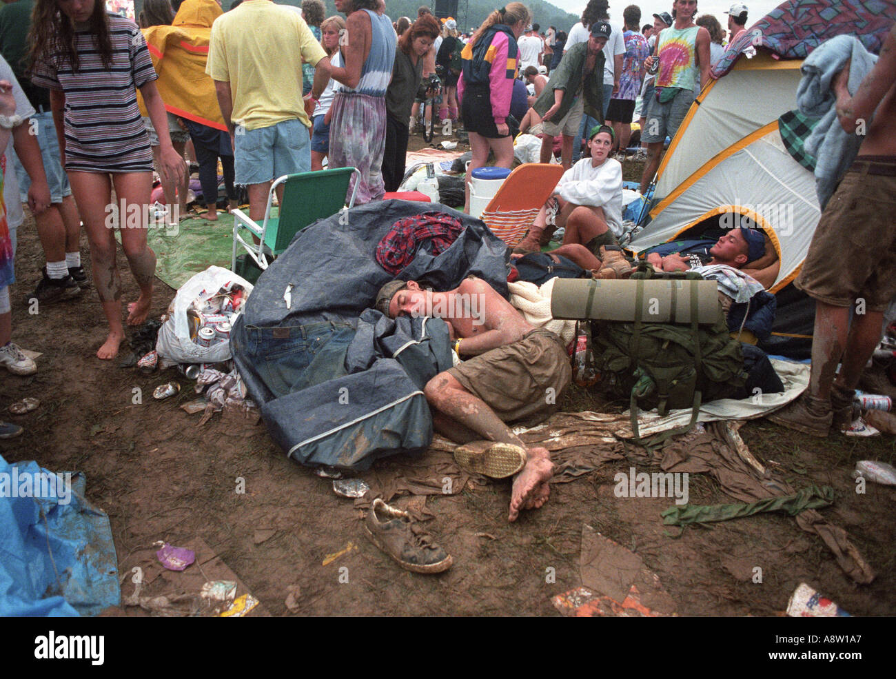 I postumi della sbornia ragazzo giovane uomo dorme passata fuori nel fango e confusione durante il woodstock Music Festival in 1994 New York STATI UNITI D'AMERICA Foto Stock