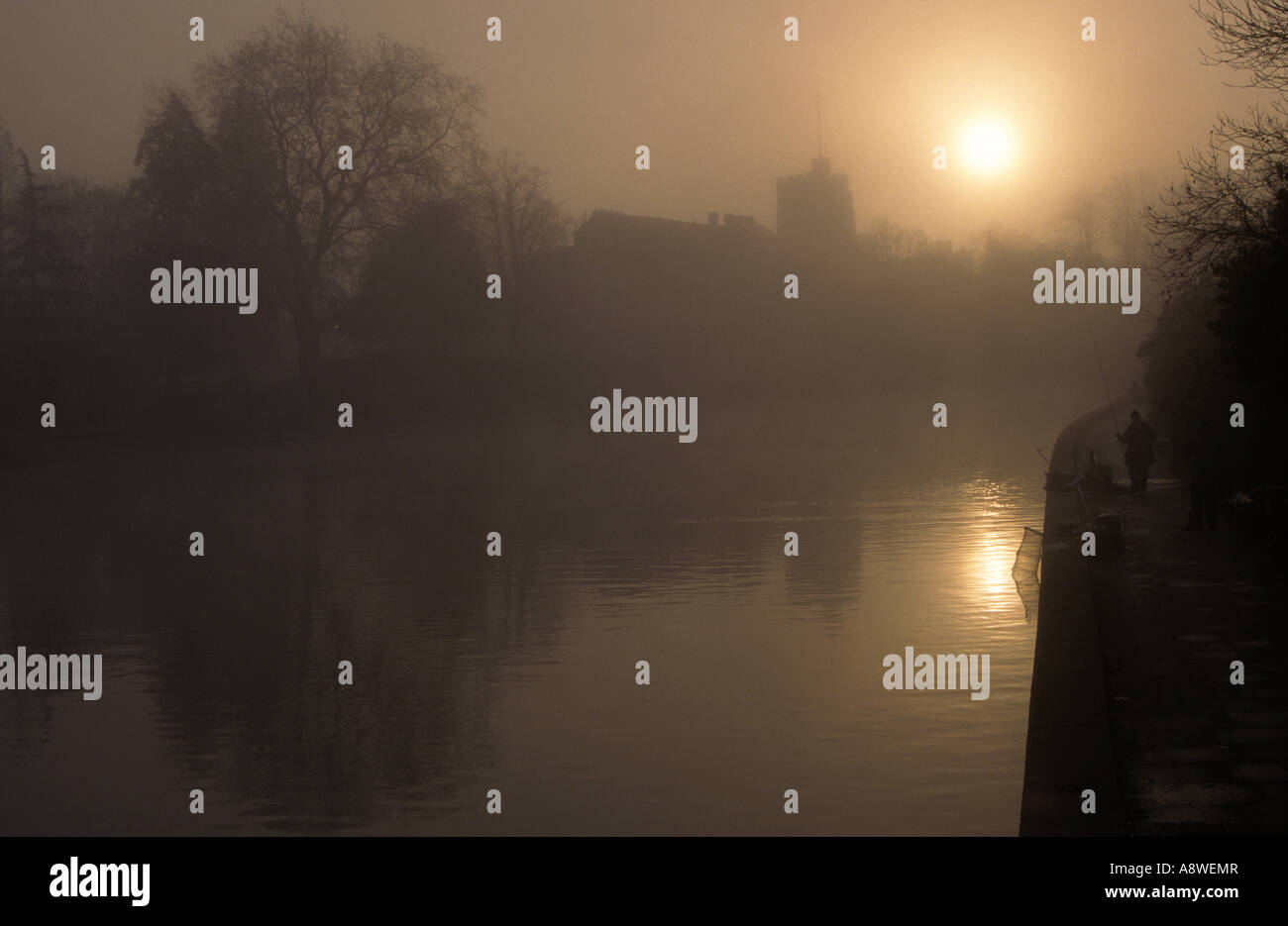 Un Misty River Medway nel centro di Maidstone con un pescatore a destra e Chiesa di Tutti i Santi dietro. Kent, Regno Unito Foto Stock