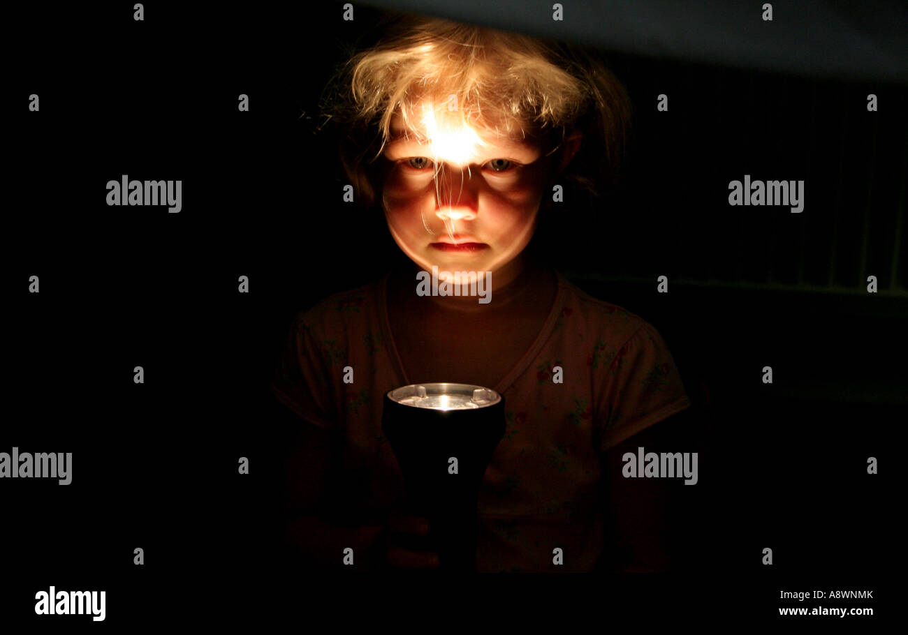 Giovane ragazza splendente spooky torcia luce nel suo viso Foto Stock