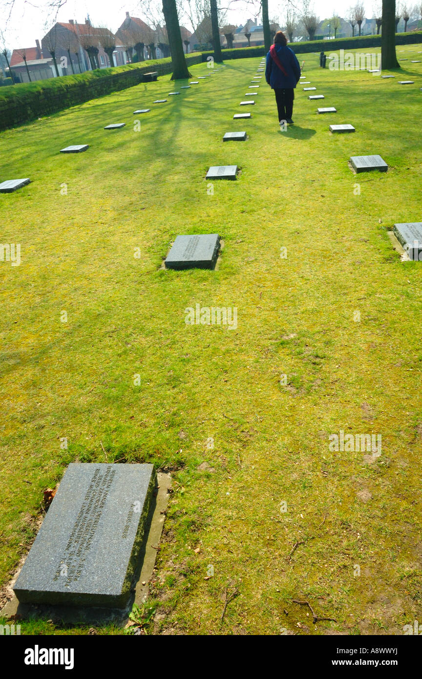 Il cimitero militare tedesco a Langemark, Belgio con una figura camminare tra le lapidi. Foto Stock