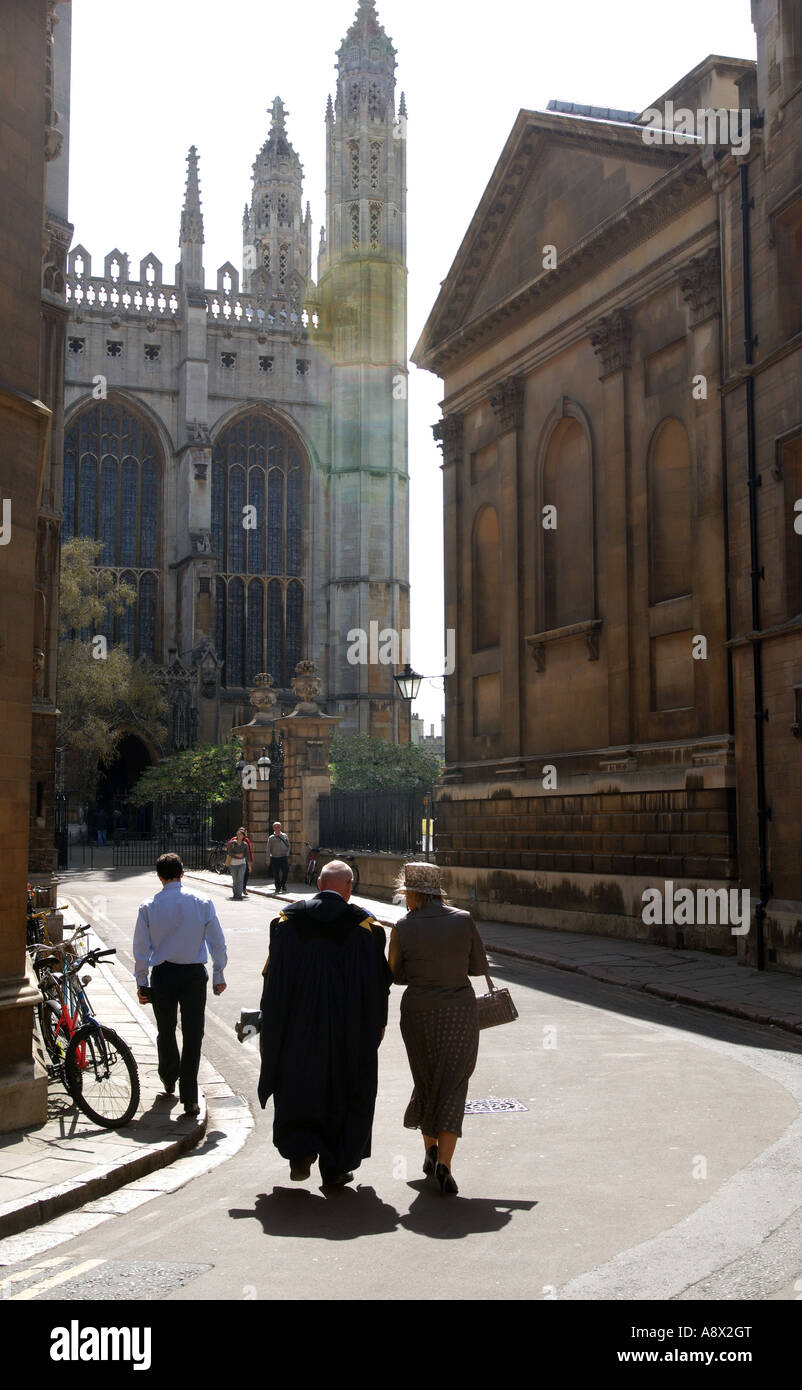 Professore e partner a camminare verso il Kings College Chapel in Cambridge Inghilterra. Retro illuminata con una forte luce del sole. Foto Stock