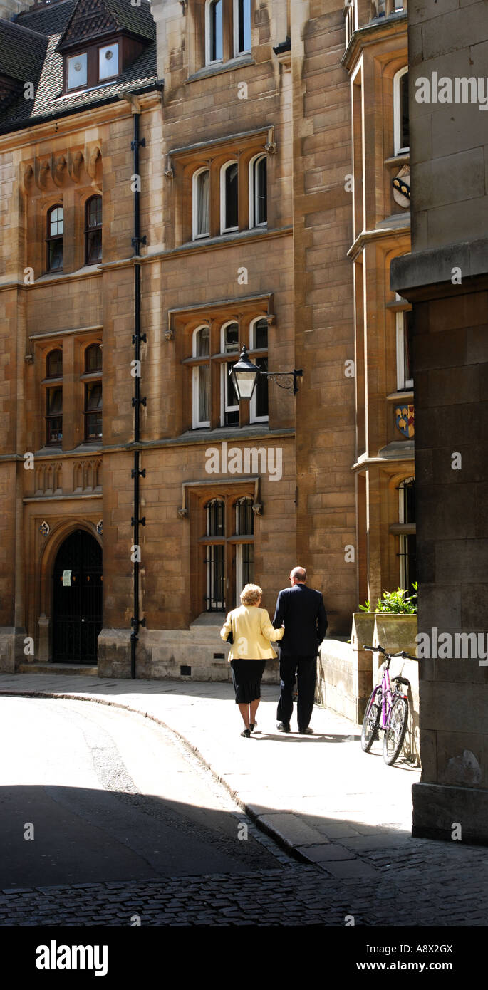 Giovane camminando verso il Kings College Chapel in Cambridge Inghilterra. Retro illuminata con una forte luce del sole. Foto Stock