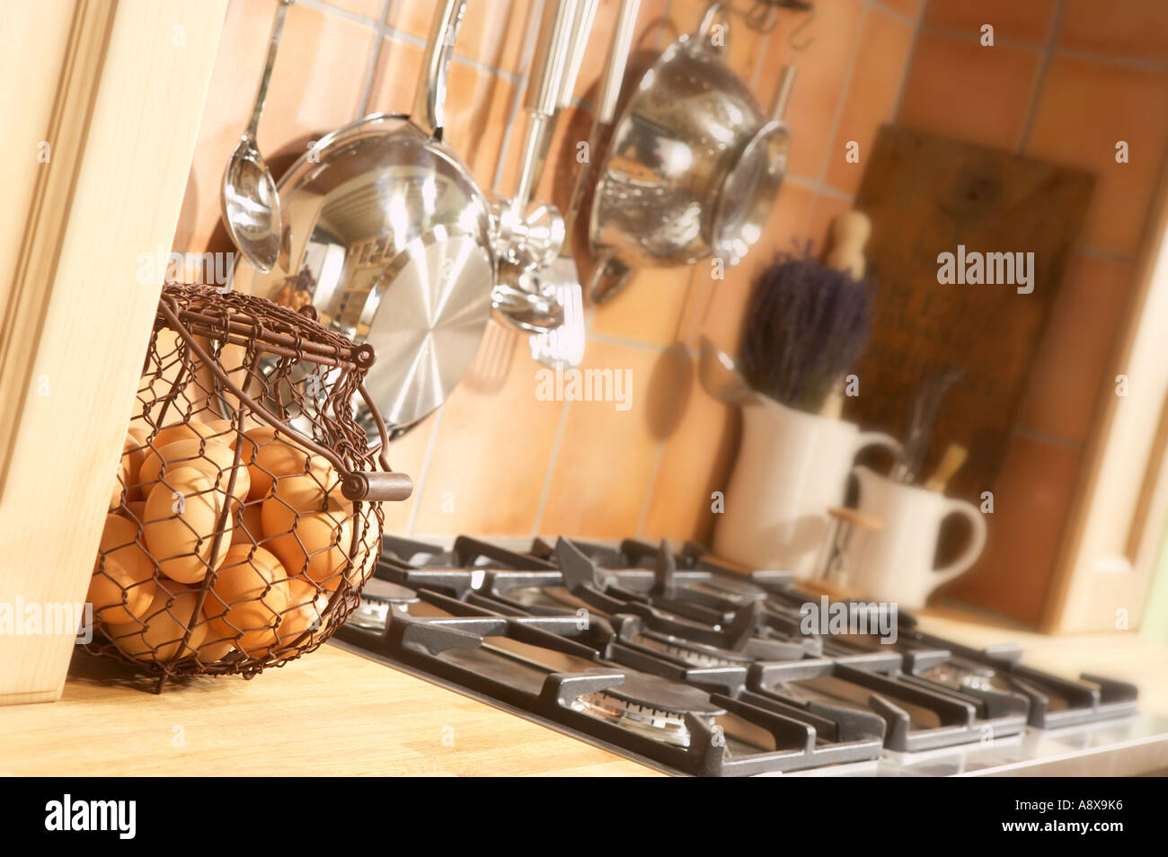 Cesto di uova fresche con utensili da cucina e fornelli a gas in cucina domestica Foto Stock