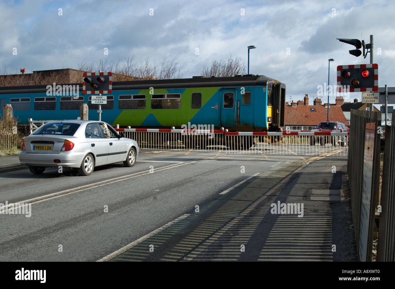 Treni pendolari passando al di sopra di un passaggio a livello a Filey North Yorkshire, Inghilterra Foto Stock