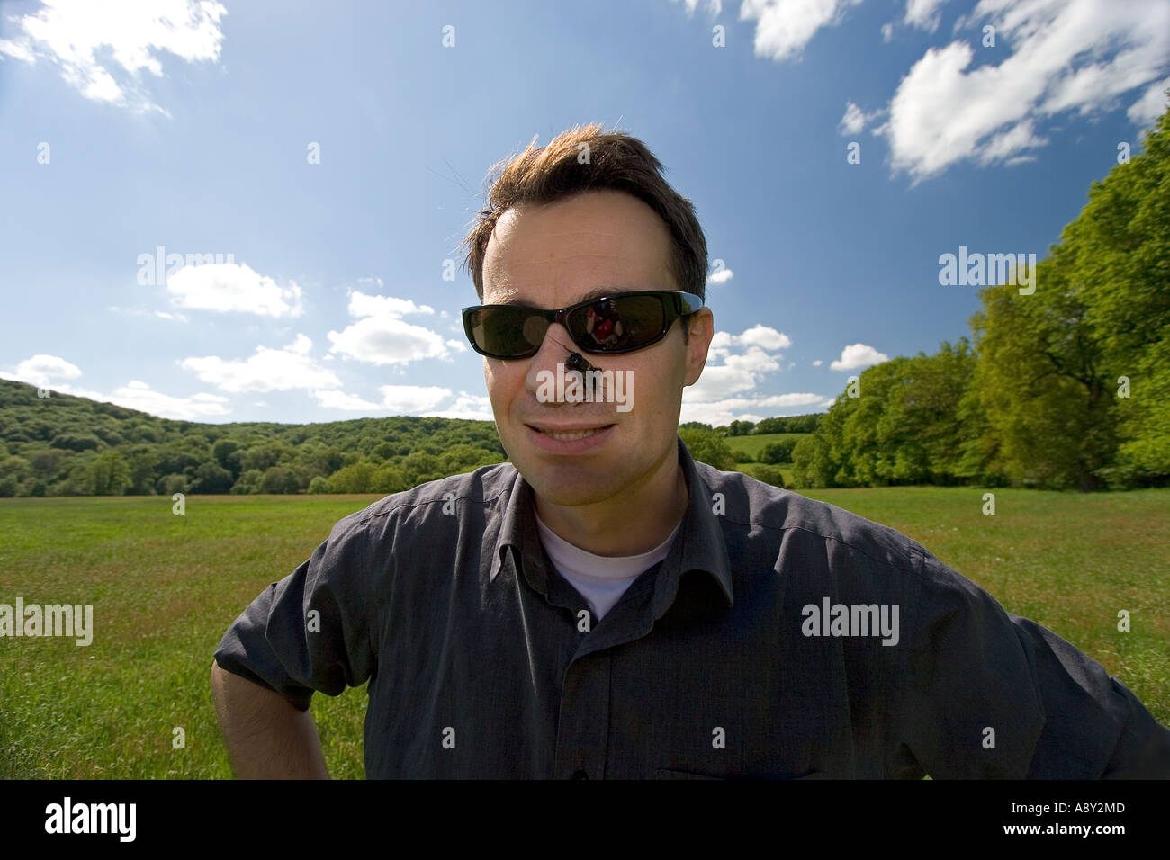 Giovane con un campo di cricket (Gryllus campestris) sul naso (Francia). Jeune homme avec onu grillon sur le nez (Francia). Foto Stock