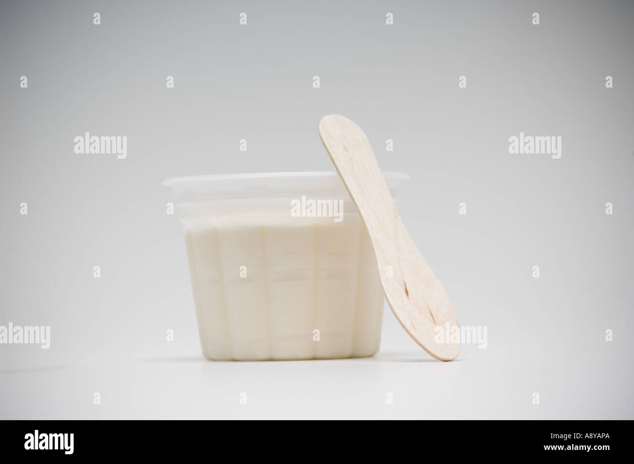 Coppa di gelato alla vaniglia con il cucchiaio di legno Foto Stock