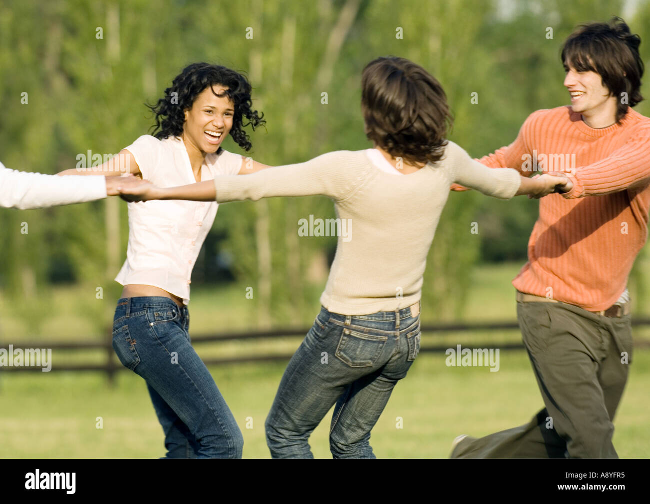 Giovani amici adulti tenendo le mani in cerchio Foto Stock