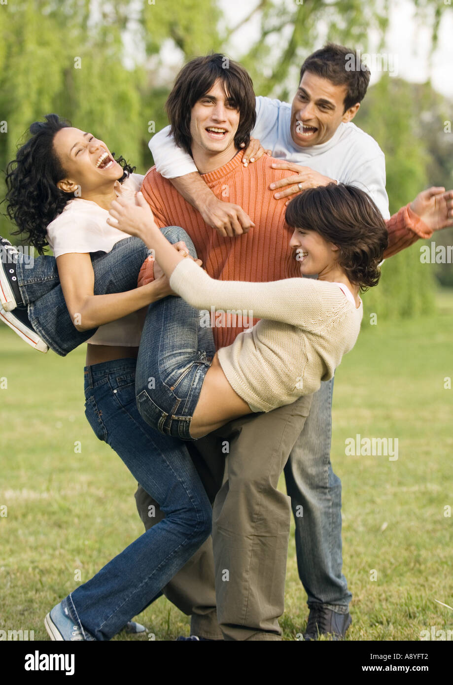 Giovani saltando su amico scherzosamente Foto Stock