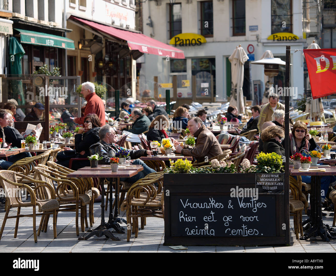 La gente seduta fuori nel sole di primavera al cafe' sul marciapiede in Antwerpen Belgio Anversa Foto Stock