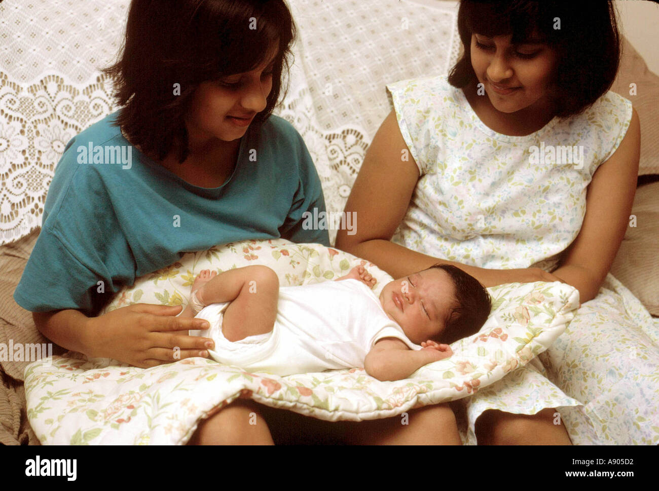 Due giovani ragazze holding nuovo baby Foto Stock