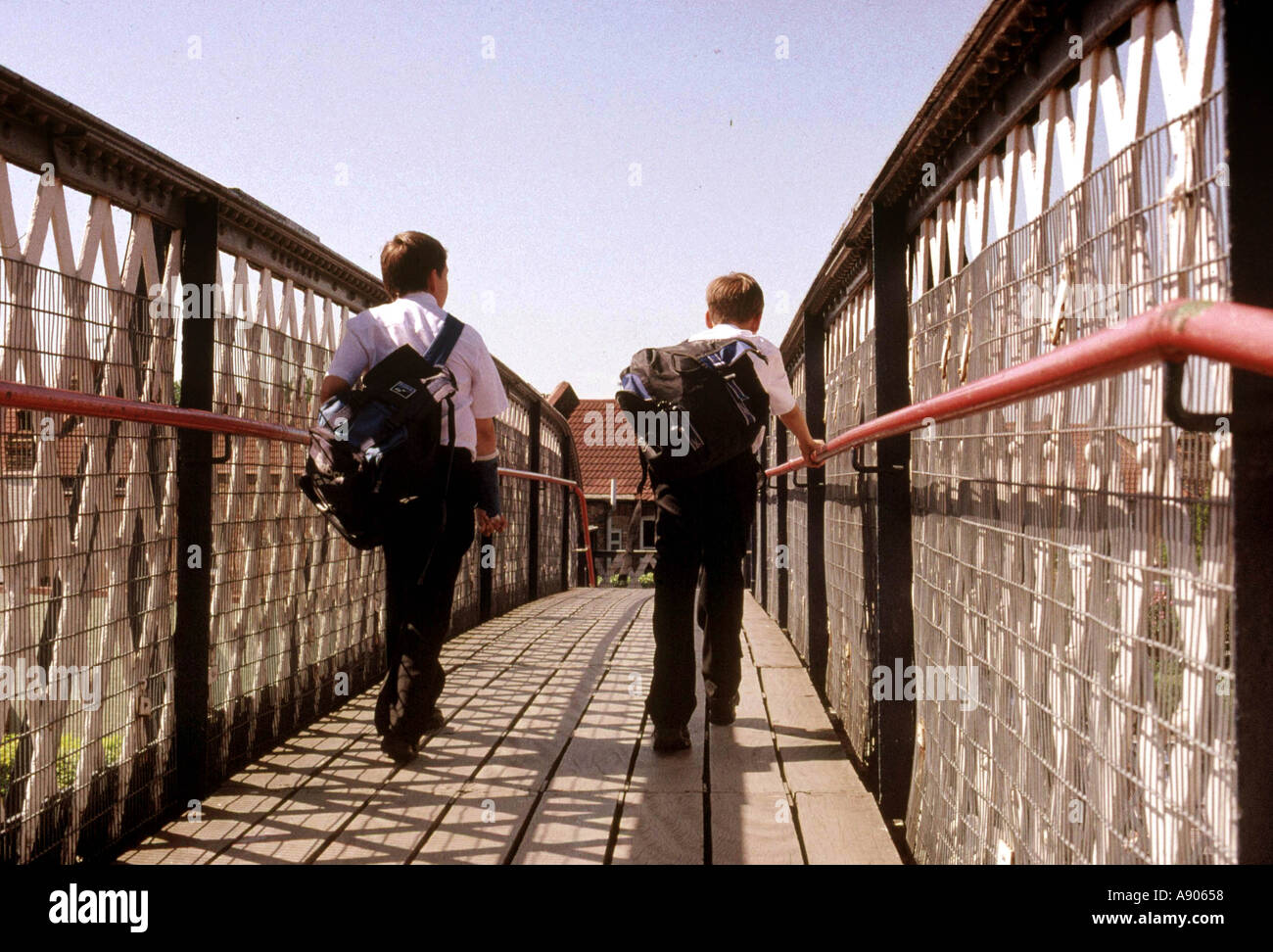 Due scolari camminare su ferrovia su passerella Foto Stock