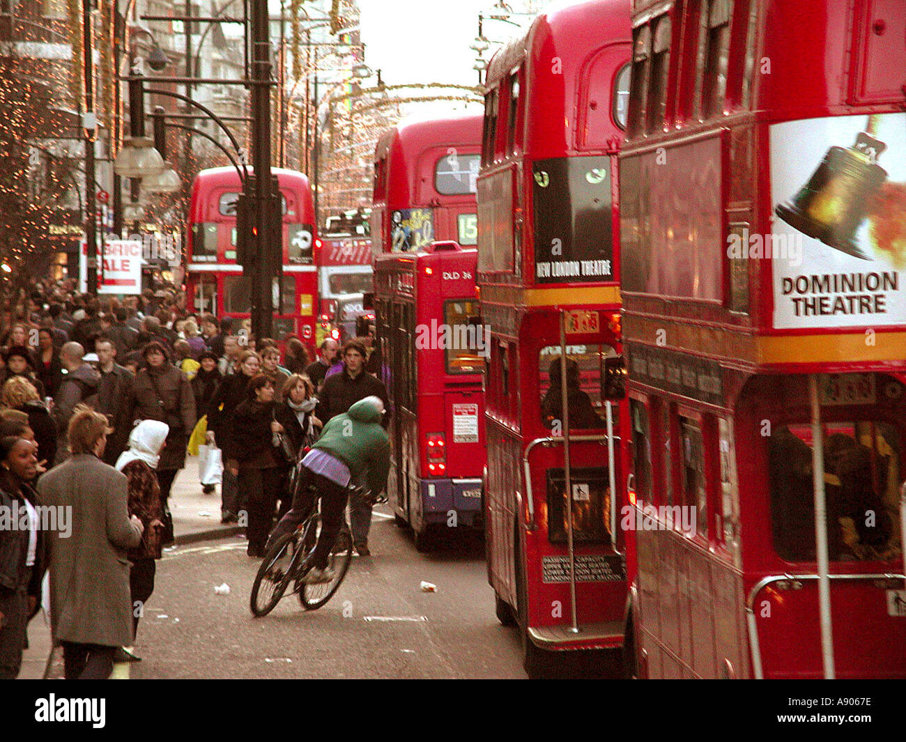 Gli autobus di Londra e il ciclista sulla affollata Oxford Street Foto Stock