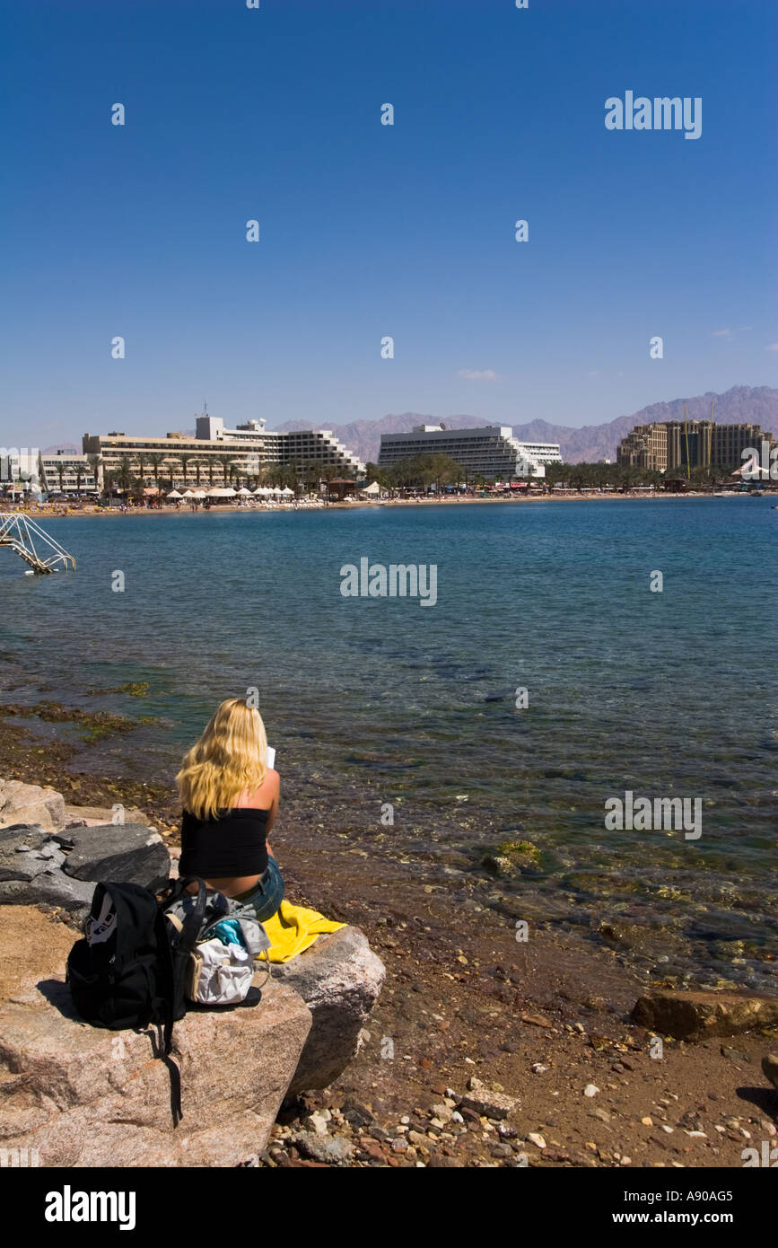 Una donna sulla riva si affaccia Eilat Foto Stock