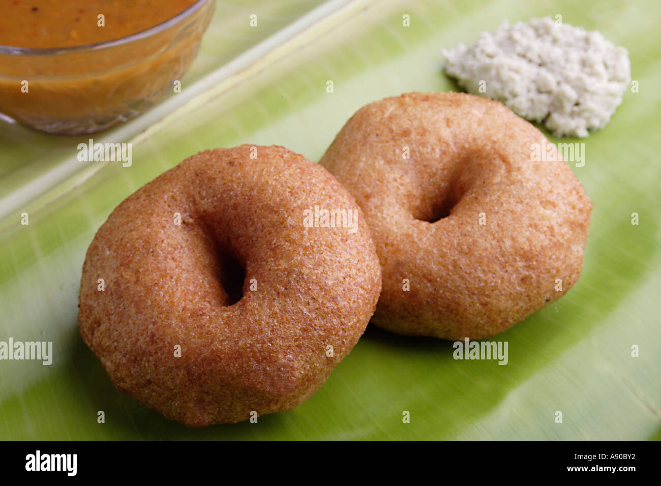 wada di merendino fritto indiano su foglia di banana con chutney sambhar Foto Stock