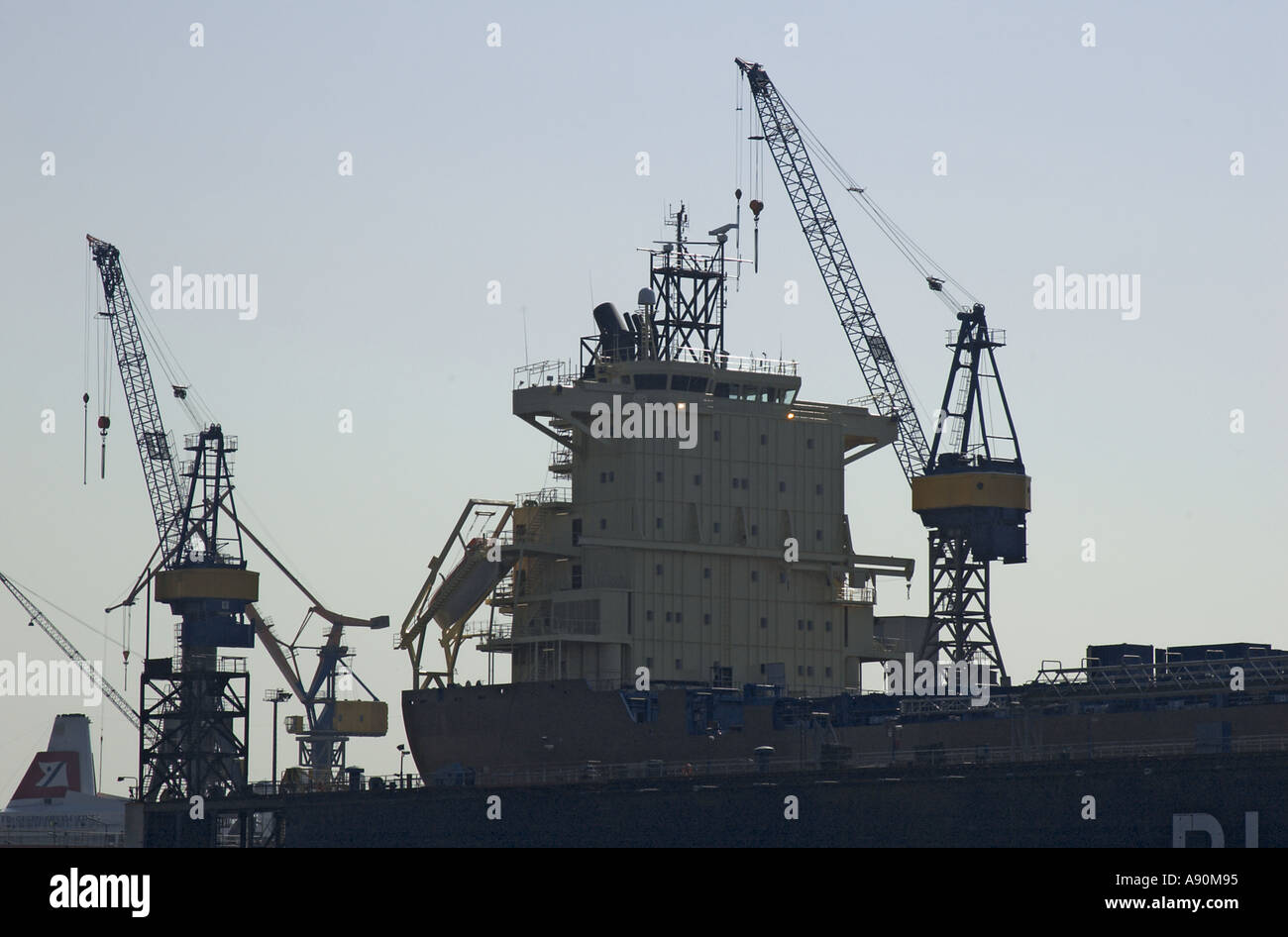Gru e contenitore nave presso il cantiere navale di Blohm Voss e al porto di Amburgo Germania Foto Stock