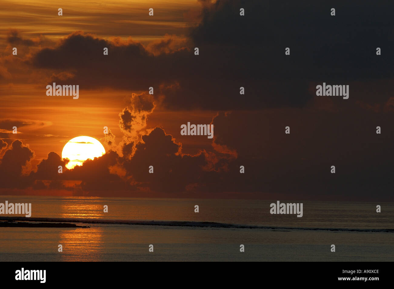 Sunrise - Sun che si innalza sopra acqua nuvole e mare con red sky Foto Stock