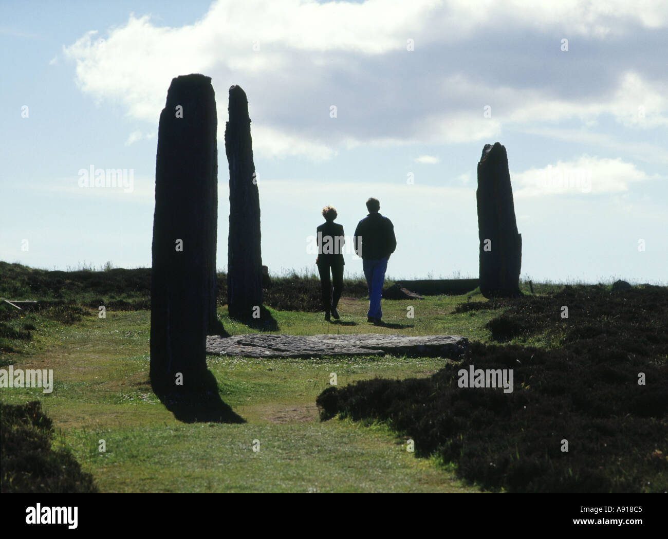 dh Neolitico in piedi pietre ANELLO DI BRODGAR ORKNEY SCOZIA Turismo Coppia camminando gente uomo donna turisti uk estate Foto Stock