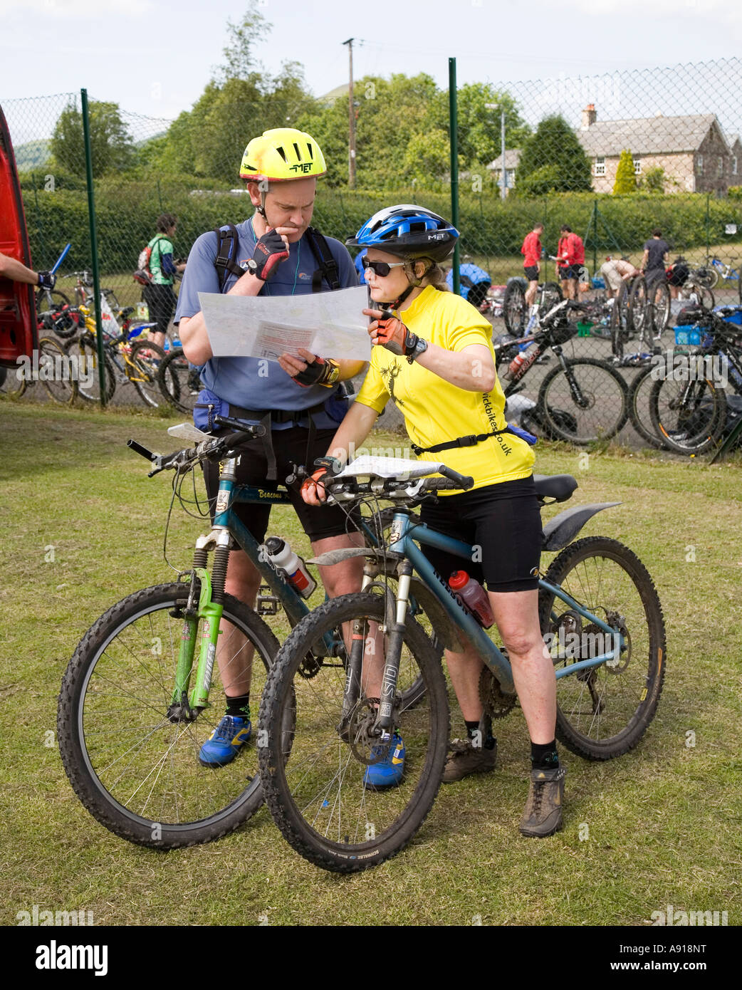 Due persone che studiano la mappa per la bicicletta in fase di gara avventura Wales UK Foto Stock