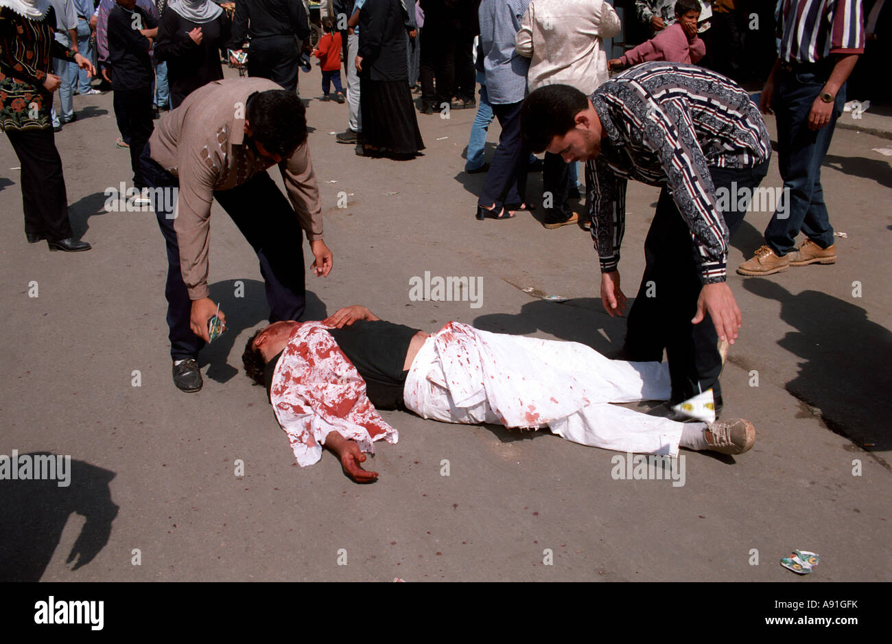 Due uomini di prelevare uomo ferito Foto Stock