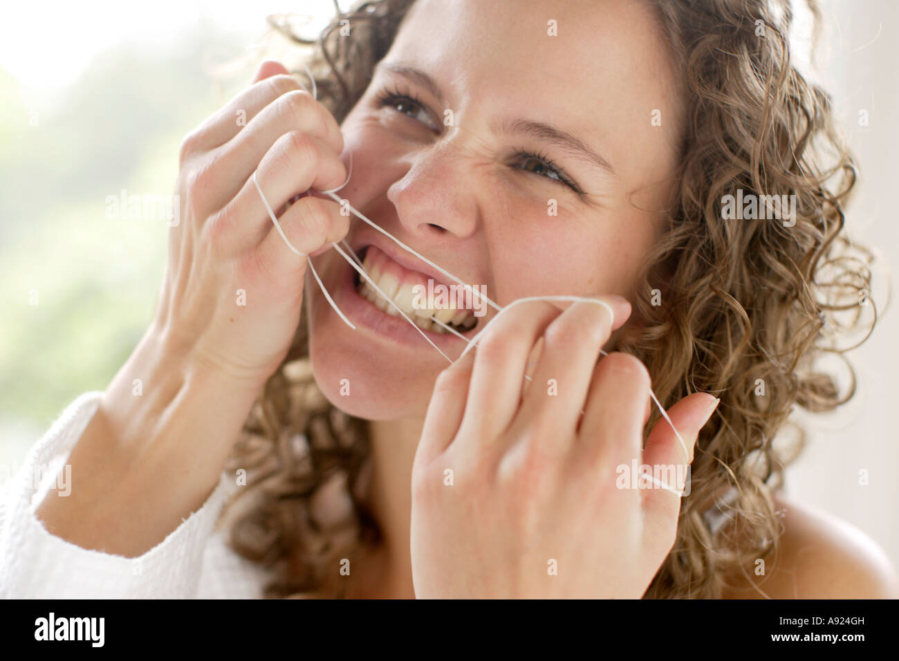 Ragazza denti filo interdentale Foto Stock