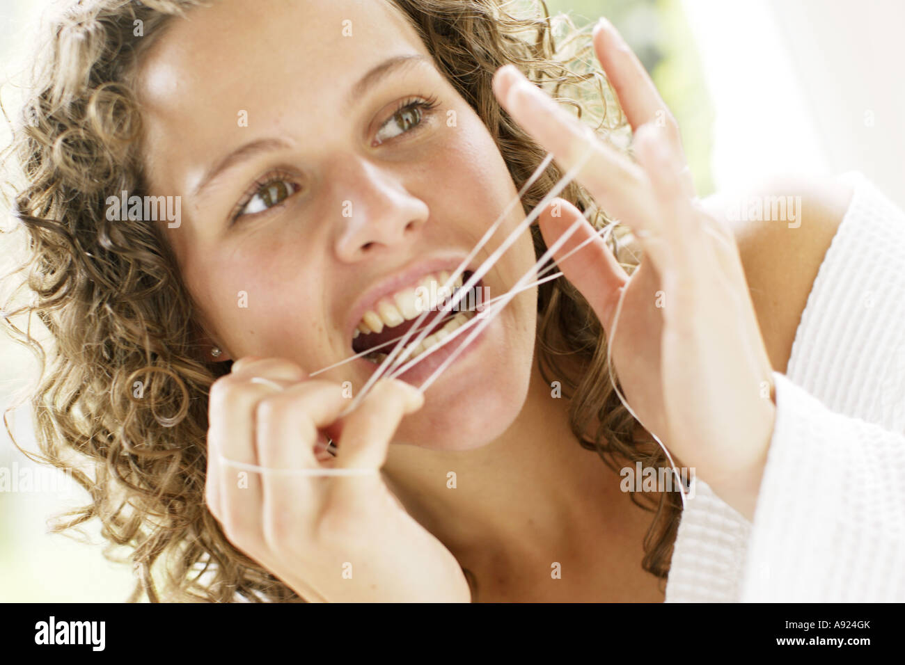 Ragazza denti filo interdentale Foto Stock