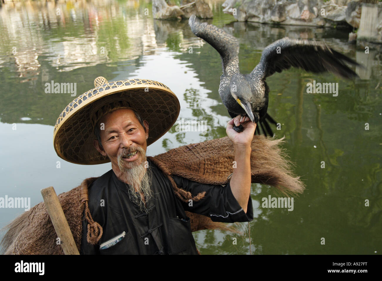 Fisherman indossando cappello di bambù e paglia rivestire con i cormorani yangshuo, Guillin, provincia di Guangxi Cina. Foto Stock