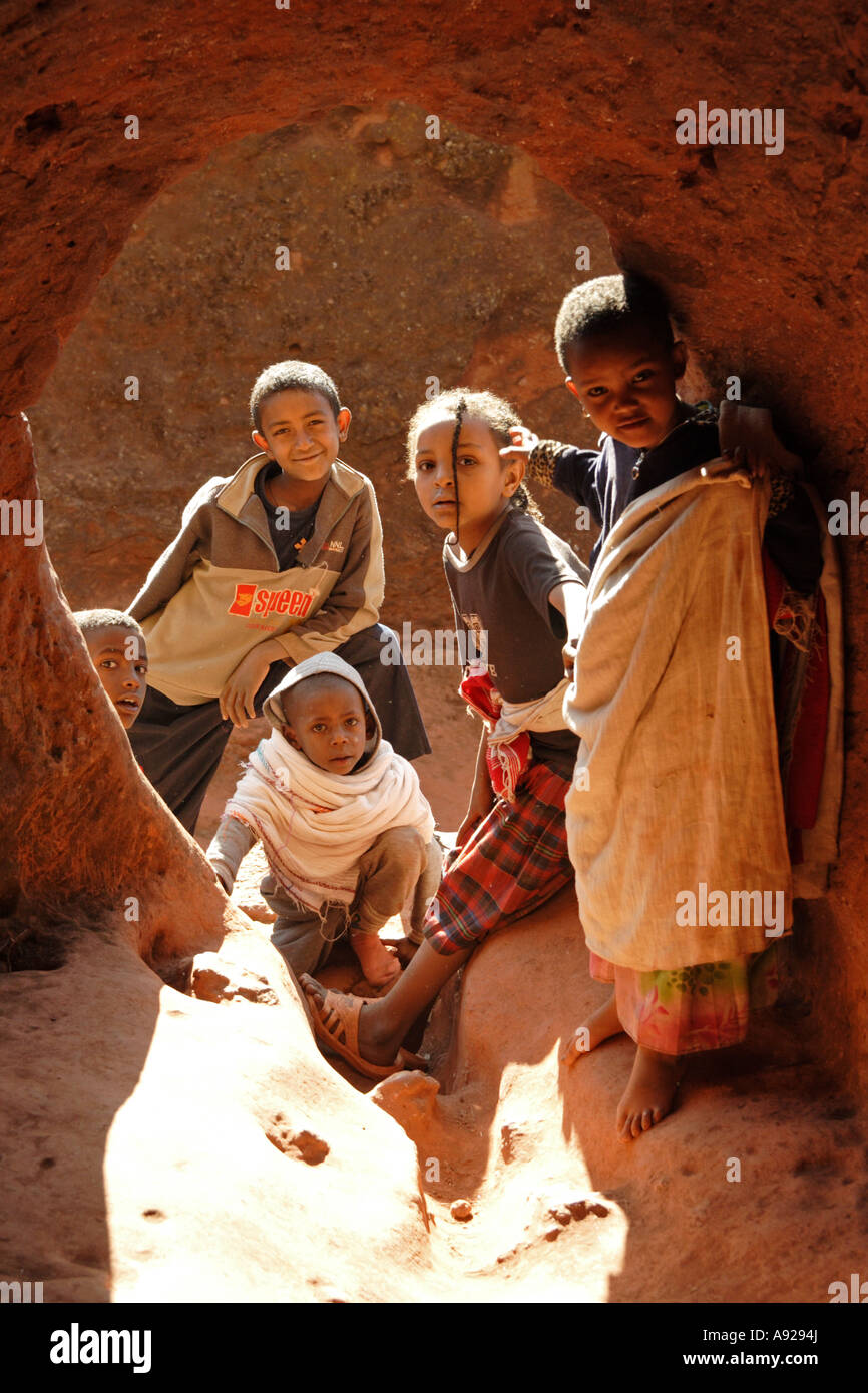 Bambini etiopi giocare al sole in un passaggio attraverso il complesso di roccia scavate le Chiese a Lalibela, Etiopia 2006 Foto Stock