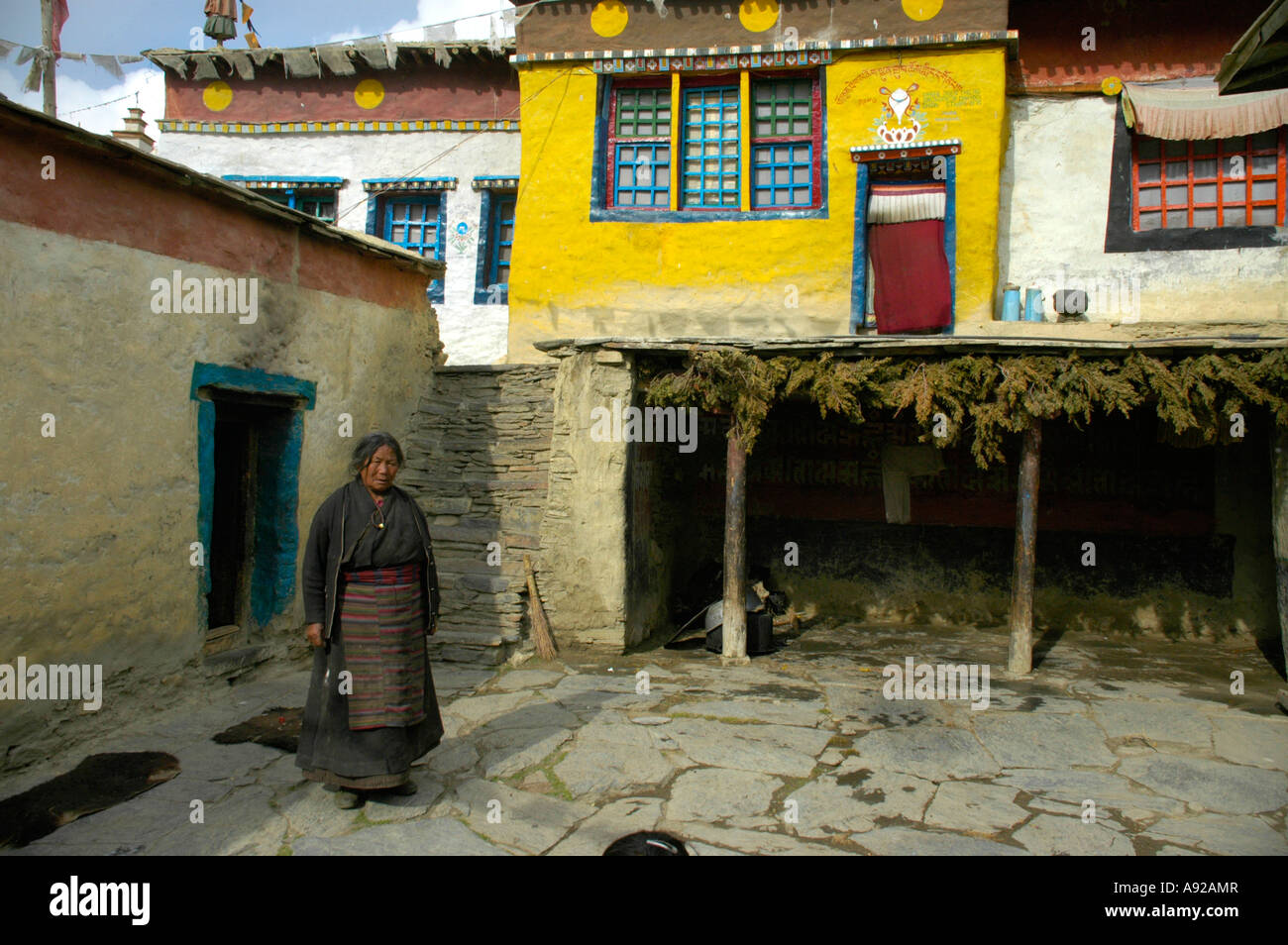 La donna nel tradizionale abito tibetano nel cortile del monastero di Tashi Gompa Phu Nar-Phu Regione Annapurna Nepal Foto Stock