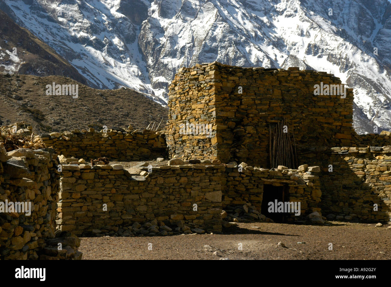 Le case di pietra e coperta di neve pendio montano Kyang Nar-Phu Regione Annapurna Nepal Foto Stock