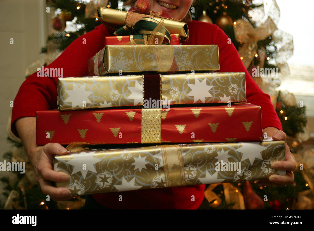 Close-up di una persona che porta un mucchio di regali di Natale Foto Stock