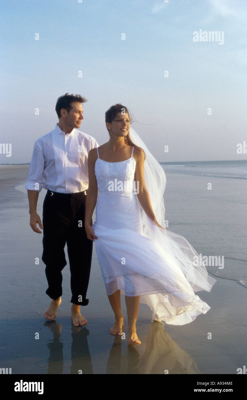 Sposa giovane di camminare sulla spiaggia Foto Stock