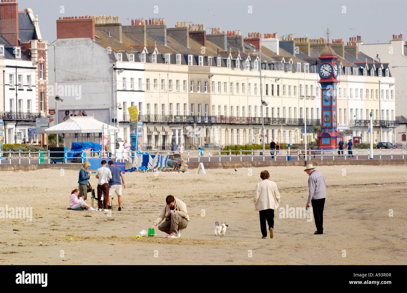 Vista sulla spiaggia con i villeggianti guardando verso il lungomare alberghi e pensioni a Weymouth Dorset Southern England Regno Unito Foto Stock