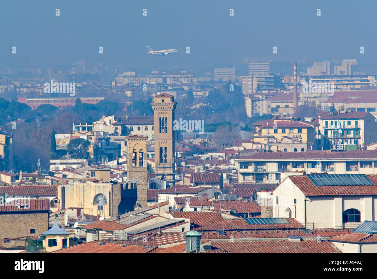 Antenna orizzontale un ampio angolo di visione attraverso i tetti di terracotta di Firenze con un piano Aitalia venuta in terra a distanza Foto Stock