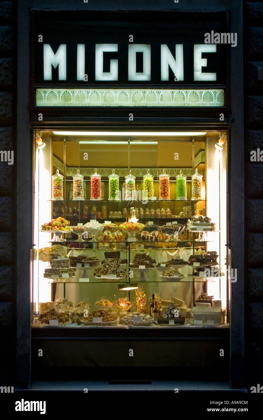 Verticale tempo di notte close up di un italiano 'La Pasticceria " torta e dolciumi finestra illuminata. Foto Stock