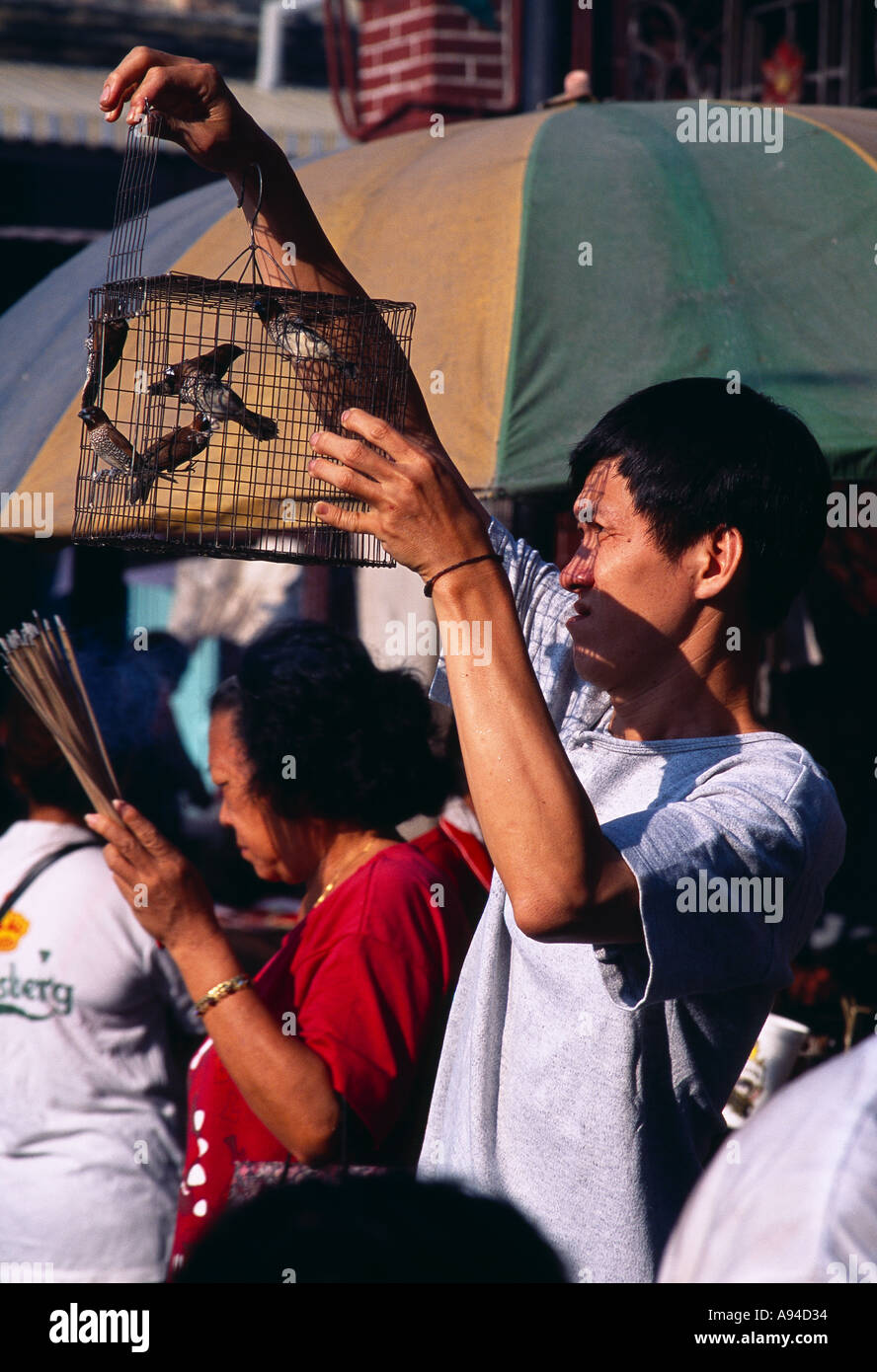 MALAYSIA Penang Georgetown Kuan Yin Teng il Tempio della Dea della Misericordia uomo rilasciando uccelli da gabbia per guadagnare merito nell'aldilà Foto Stock