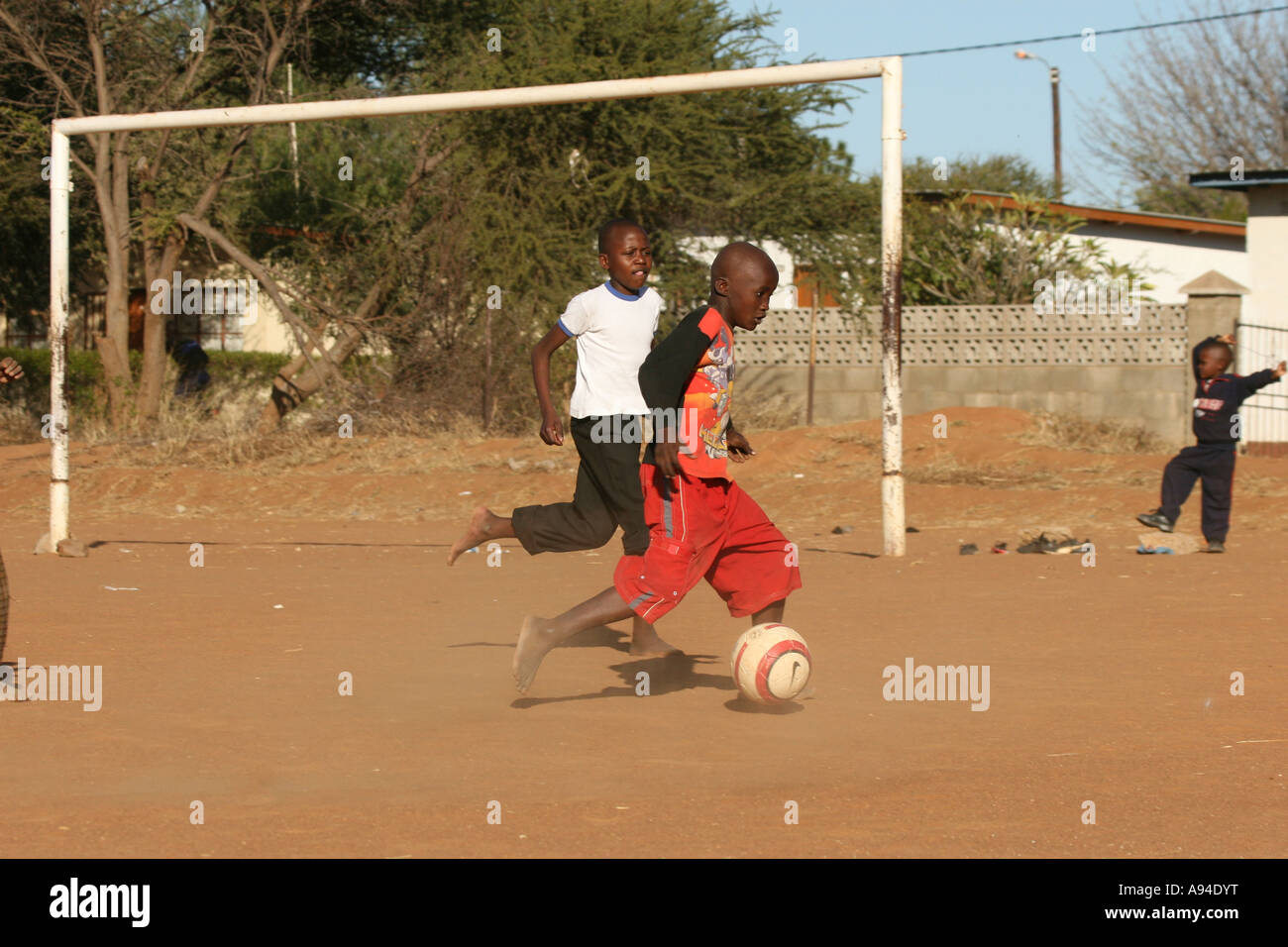 Ragazzi che giocano a calcio su un polveroso campo da calcio Gaborone Botswana Foto Stock