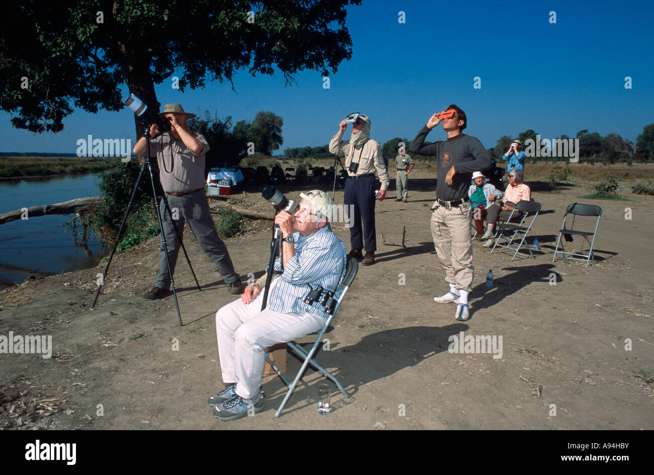 I turisti guarda il 2001 piena eclissi solare attraverso telecamere e telescopi schermato con dispositivi Foto Stock