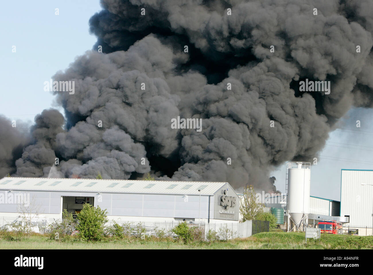 Enorme pennacchio di nero grigio fumo da edificio industriale Incendio al magazzino medico coleraine Foto Stock