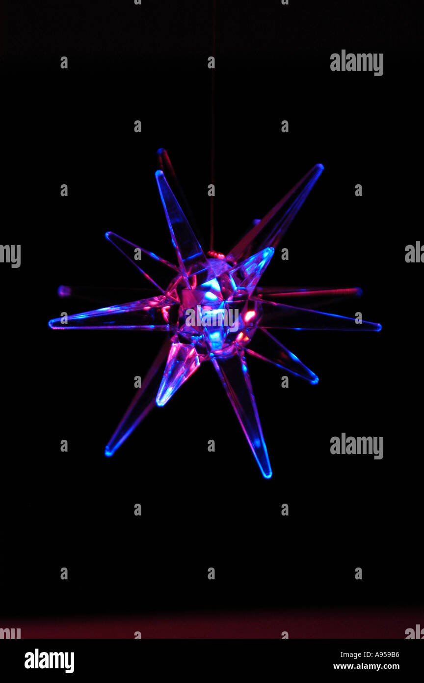 Luce blu a stella illuminata che oscilla e sfocata con il movimento. Su sfondo nero. Foto Stock